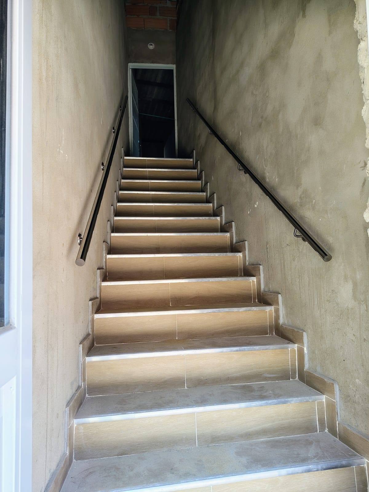 Pasamanos metálico instalado en escalera de punto fijo